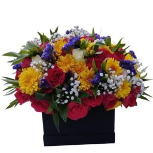 A striking floral arrangement featuring red roses, bright yellow chrysanthemums, delicate white baby’s breath, and pops of purple flowers, beautifully arranged in a sleek black box. The vibrant color combination adds a touch of elegance and joy, making it an ideal gift for any special occasion.