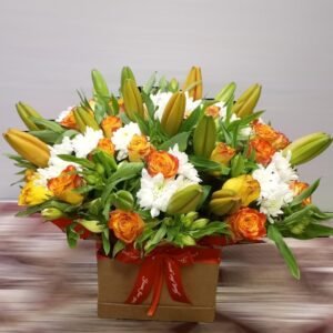 A striking floral arrangement featuring a mix of orange roses, white chrysanthemums, and fresh green lilies in bud form. Set in a stylish box with a vibrant red ribbon, this elegant display brings a warm and cheerful touch, making it perfect for celebrations, gifts, or special occasions.