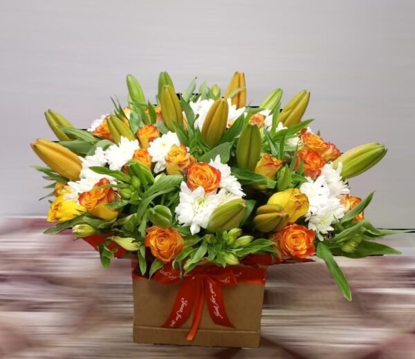 A striking floral arrangement featuring a mix of orange roses, white chrysanthemums, and fresh green lilies in bud form. Set in a stylish box with a vibrant red ribbon, this elegant display brings a warm and cheerful touch, making it perfect for celebrations, gifts, or special occasions.