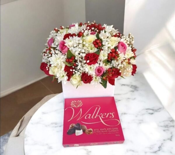 This arrangement is a delightful combination of red, white, and pink flowers, beautifully arranged in a white box. It is paired with a box of **Walkers chocolates**, making it a perfect gift for a loved one on a special occasion!