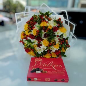 A beautiful bouquet featuring a vibrant mix of yellow and red roses, white flowers, and lush greenery, elegantly wrapped. Paired with a delicious box of Walkers chocolates, this combination makes for a perfect gift to express love and appreciation.