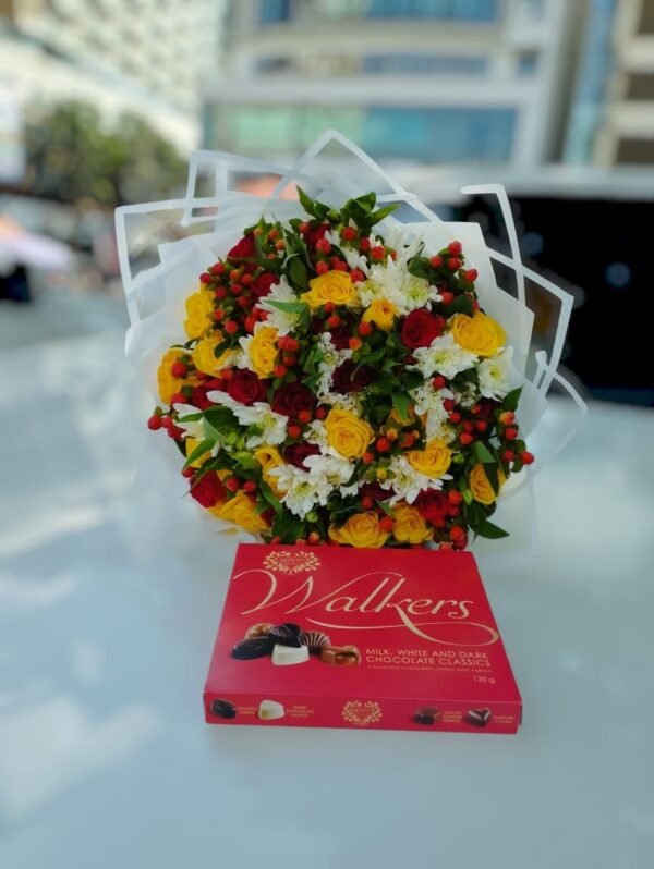 A beautiful bouquet featuring a vibrant mix of yellow and red roses, white flowers, and lush greenery, elegantly wrapped. Paired with a delicious box of Walkers chocolates, this combination makes for a perfect gift to express love and appreciation.