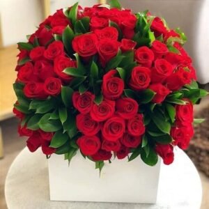 Exquisite arrangement of red roses with green leaves in a white gift box, perfect for romantic gestures and special celebrations.