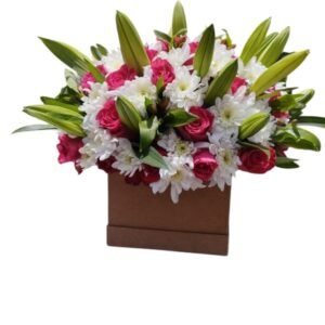 This is a beautiful floral arrangement in a box, featuring pink roses, white chrysanthemums, and fresh lilies with their buds still closed. The mix of colors and textures creates a stunning and elegant display—perfect for gifting or decorating a special space!