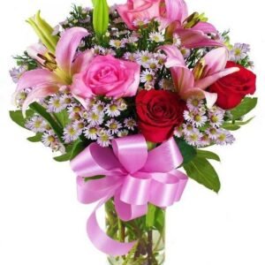 Charming bouquet of pink lilies, pink and red roses, purple aster flowers, and greenery, tied with a pink ribbon in a glass vase.